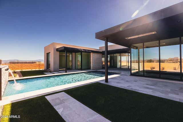 view of swimming pool with pool water feature and a patio area