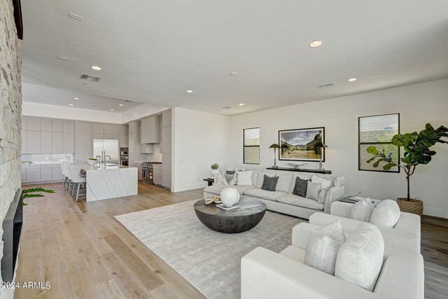 living room with sink and light wood-type flooring