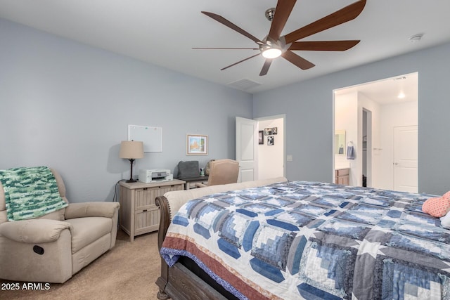 bedroom featuring ensuite bathroom, light carpet, and ceiling fan