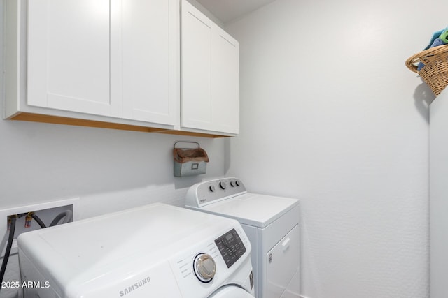 clothes washing area featuring cabinets and independent washer and dryer