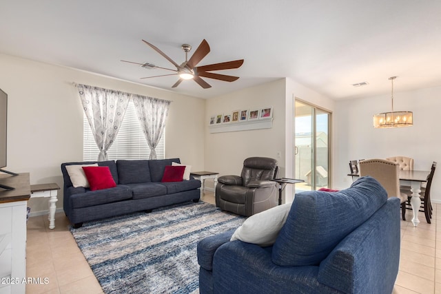 tiled living room featuring ceiling fan with notable chandelier and a wealth of natural light