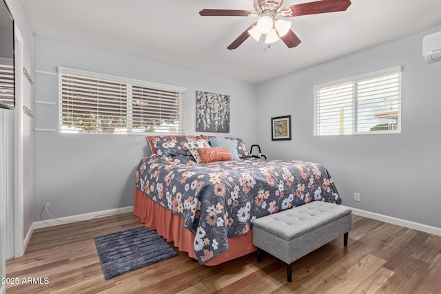 bedroom with ceiling fan, baseboards, and wood finished floors