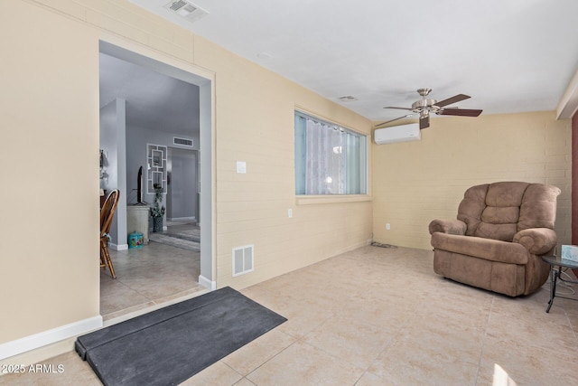 living area featuring visible vents, ceiling fan, tile patterned flooring, and a wall unit AC