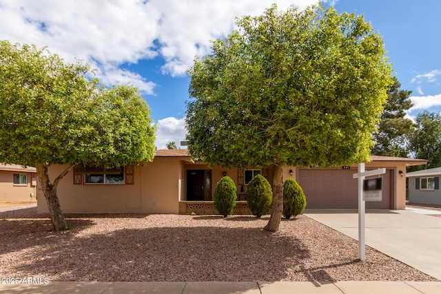 view of front of property featuring concrete driveway, a garage, and stucco siding