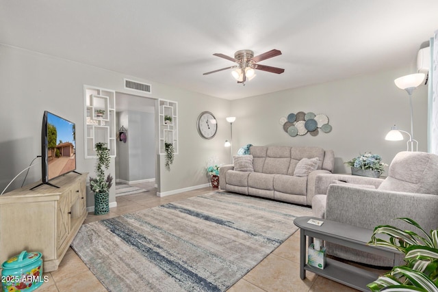 living area featuring light tile patterned floors, baseboards, visible vents, and ceiling fan