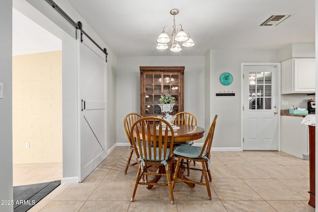 dining room featuring light tile patterned floors, a barn door, a notable chandelier, and visible vents