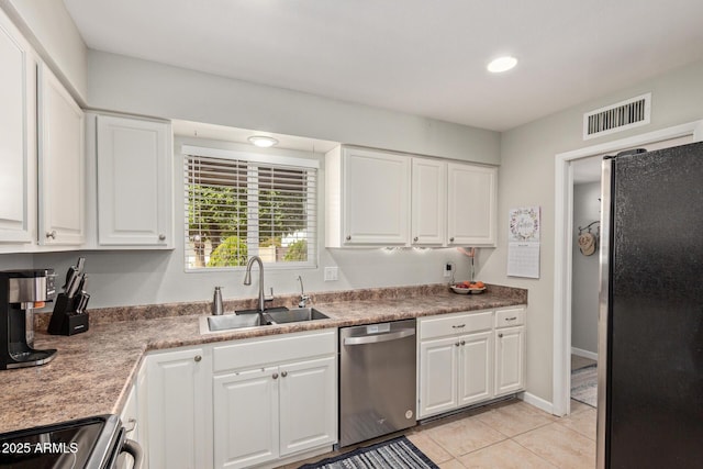 kitchen featuring light tile patterned floors, visible vents, a sink, stainless steel appliances, and white cabinetry