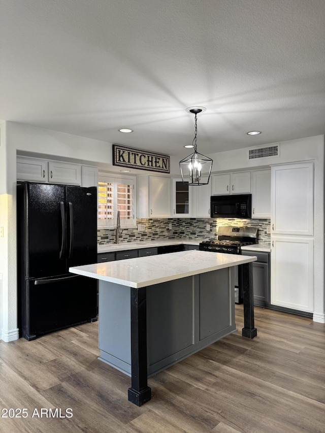 20722 N 38th St, Phoenix, AZ 85050 - kitchen featuring black appliances, tasteful backsplash, light countertops, dark wood finished floors, and hanging light fixtures