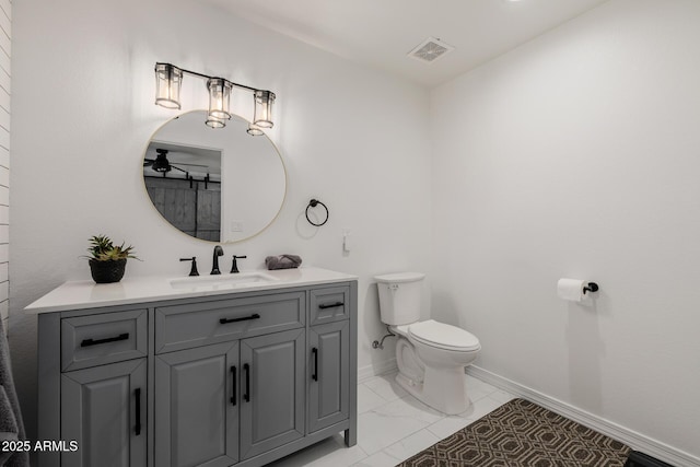2350 E Melrose St, Gilbert, AZ 85297 - bathroom featuring vanity, toilet, marble look tile flooring, baseboards, and ceiling fan