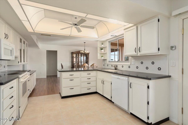 kitchen featuring light tile patterned flooring, sink, white cabinets, kitchen peninsula, and white appliances