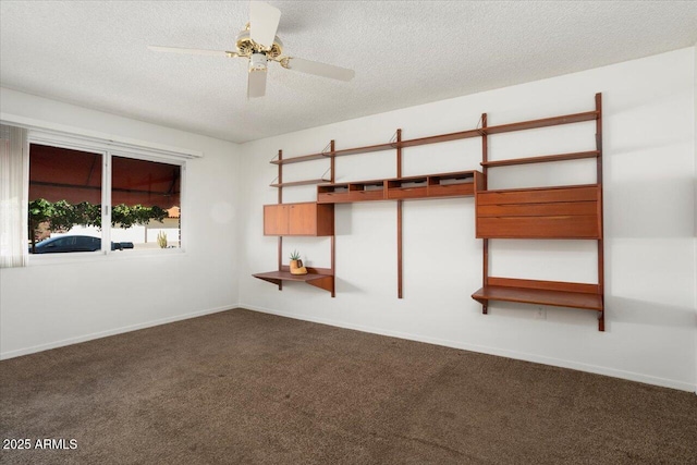 unfurnished bedroom featuring ceiling fan, dark carpet, and a textured ceiling