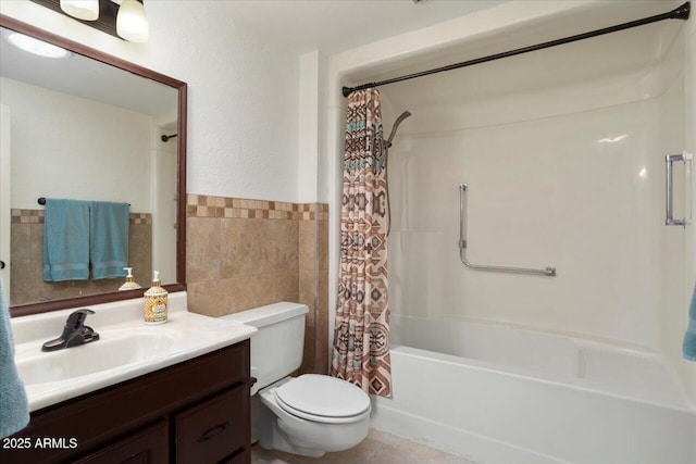 full bathroom featuring vanity, tile walls, shower / tub combo with curtain, and toilet