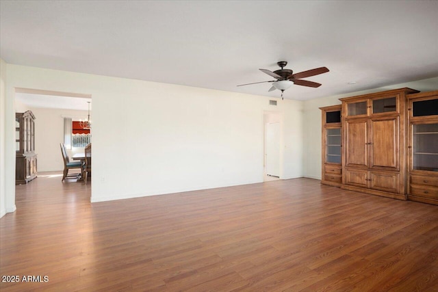 unfurnished living room with dark wood-type flooring and ceiling fan