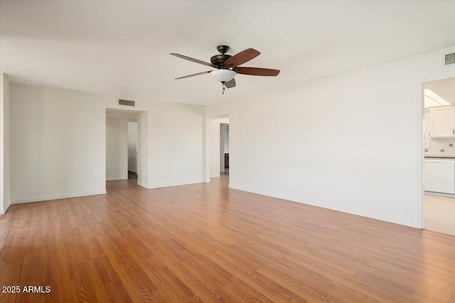 empty room with ceiling fan and light hardwood / wood-style flooring