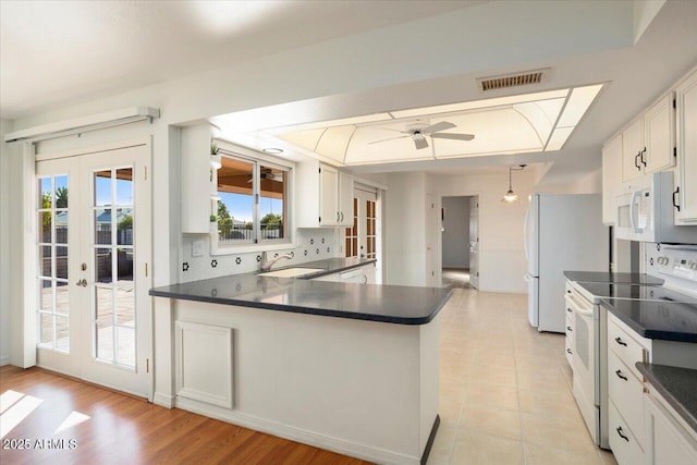 kitchen featuring white cabinetry, sink, kitchen peninsula, white appliances, and french doors