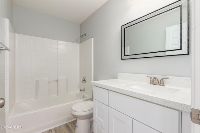 full bathroom with wood-type flooring, vanity, washtub / shower combination, and toilet