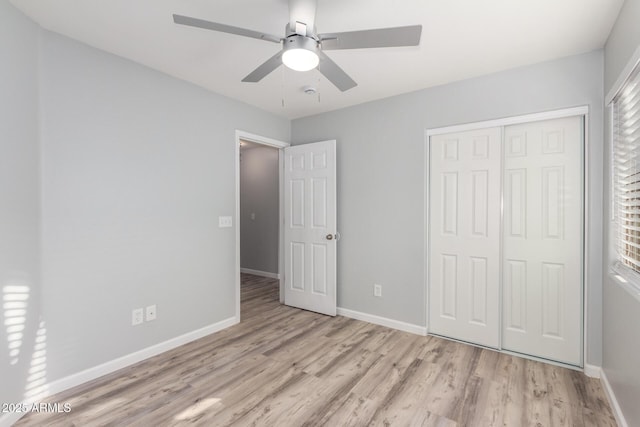 unfurnished bedroom with multiple windows, ceiling fan, light hardwood / wood-style floors, and a closet