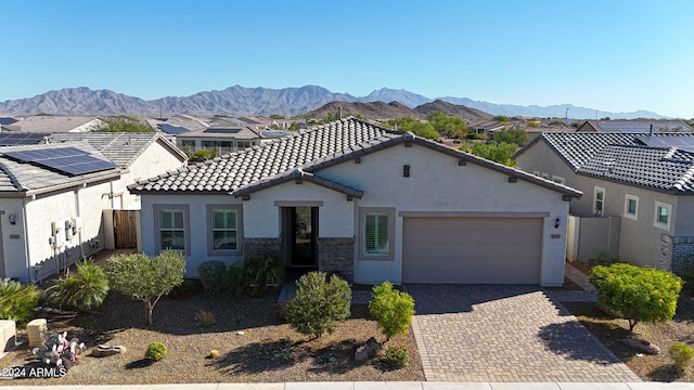 view of front of home with a mountain view and a garage