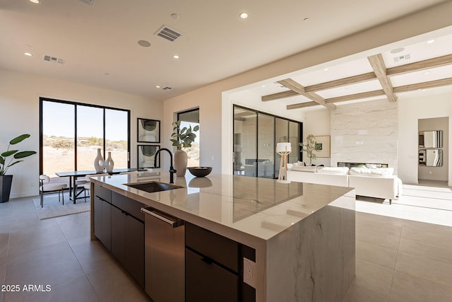 kitchen with coffered ceiling, a spacious island, beamed ceiling, and sink