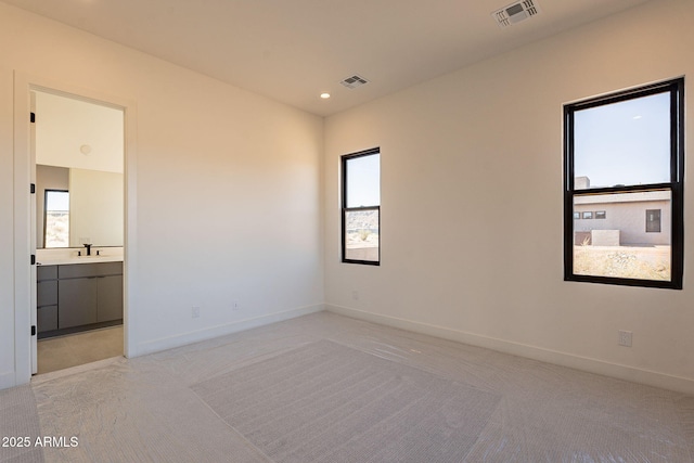 unfurnished room featuring sink and light carpet