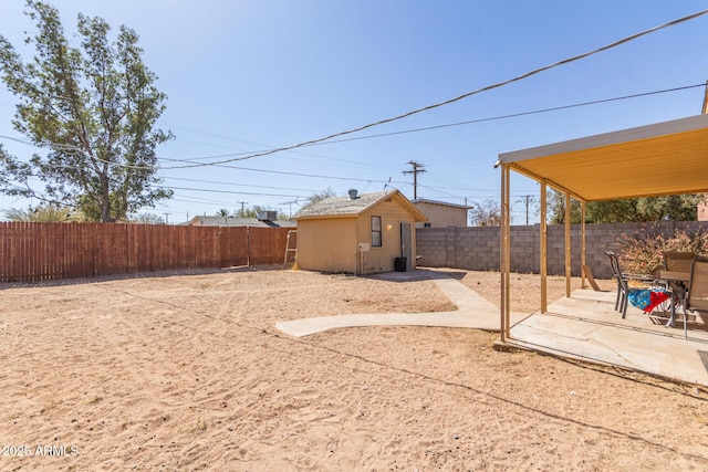 view of yard with an outbuilding, a patio area, and a fenced backyard