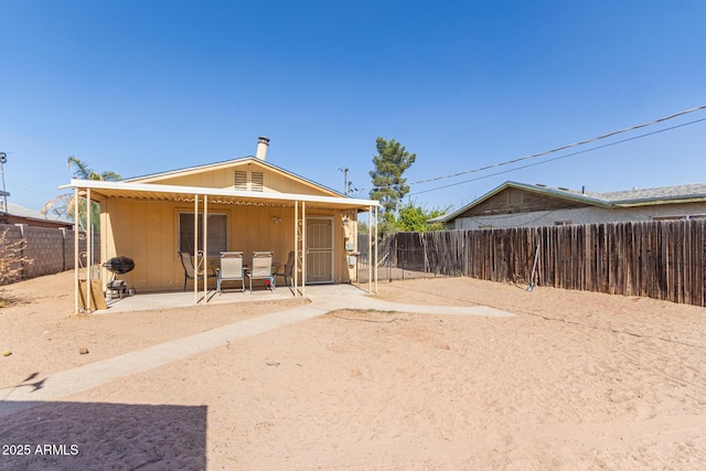 rear view of property featuring a patio area and fence