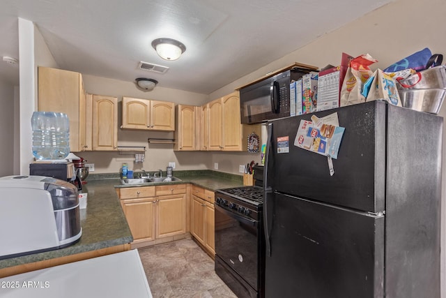 kitchen with a sink, black appliances, dark countertops, and light brown cabinets