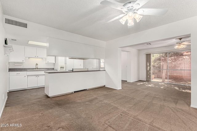 518 N Cheri Lynn Dr, Chandler, AZ 85225 - kitchen featuring a ceiling fan, a peninsula, a sink, dark countertops, and white cabinets