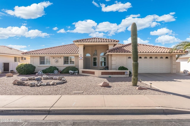 mediterranean / spanish home with a garage, driveway, a tiled roof, and stucco siding