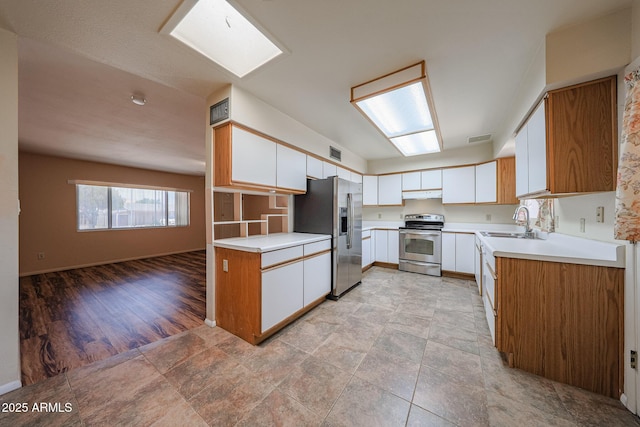 12611 N 112th Ave, Youngtown, AZ 85363 - kitchen with stainless steel appliances, a sink, under cabinet range hood, light countertops, and baseboards