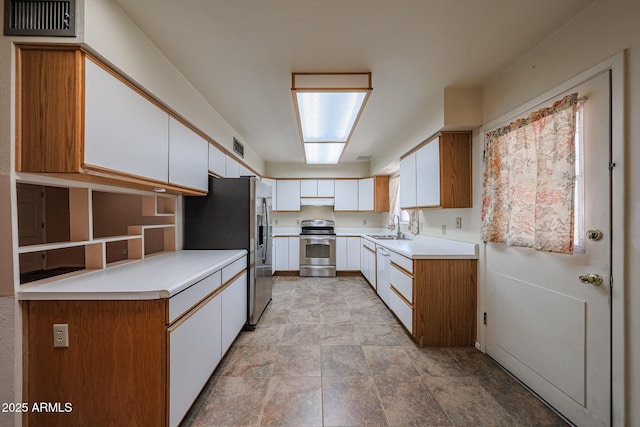12611 N 112th Ave, Youngtown, AZ 85363 - kitchen with stainless steel appliances, a sink, under cabinet range hood, white cabinetry, and light countertops