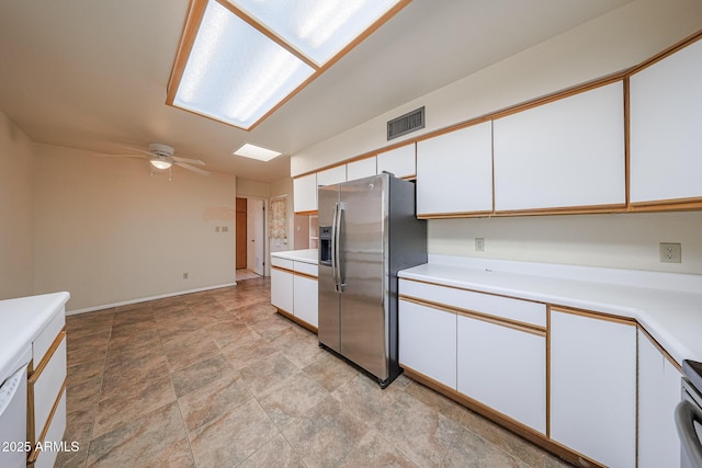 12611 N 112th Ave, Youngtown, AZ 85363 - kitchen with stainless steel fridge, light countertops, white cabinets, ceiling fan, and stone finish flooring