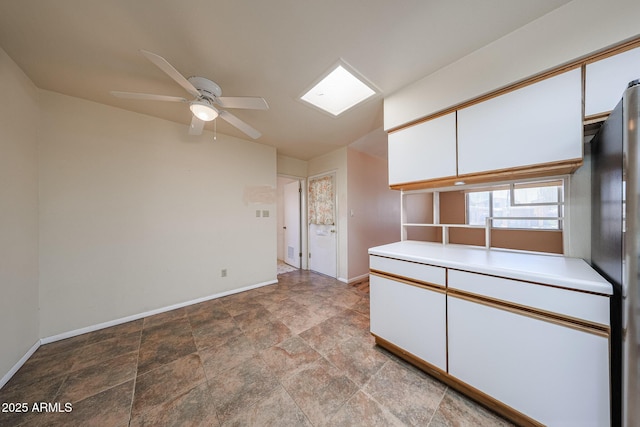 12611 N 112th Ave, Youngtown, AZ 85363 - kitchen with baseboards, light countertops, ceiling fan, and white cabinets