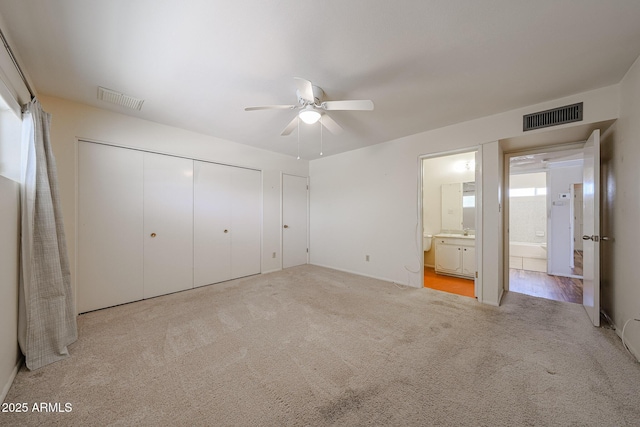 12611 N 112th Ave, Youngtown, AZ 85363 - unfurnished bedroom featuring a closet, carpet flooring, connected bathroom, a ceiling fan, and a sink