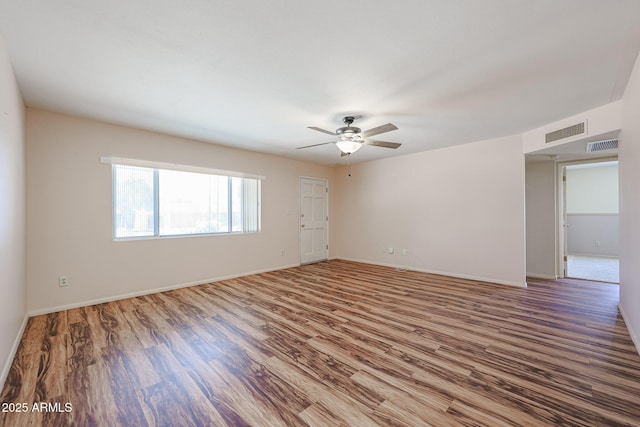 12611 N 112th Ave, Youngtown, AZ 85363 - spare room featuring wood finished floors, ceiling fan, and baseboards