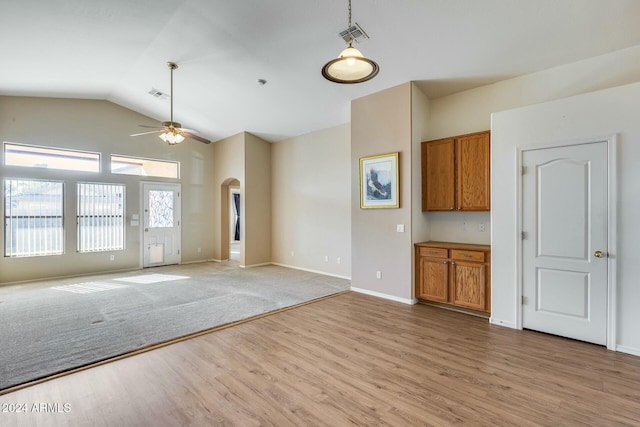 unfurnished living room with light hardwood / wood-style floors, vaulted ceiling, and ceiling fan