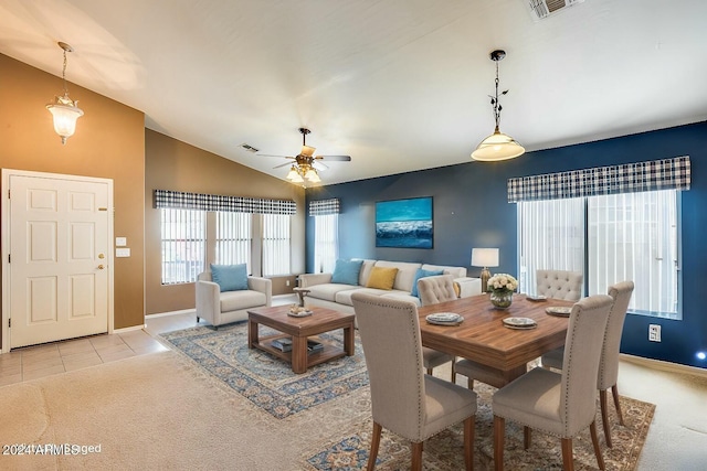 carpeted dining area with ceiling fan and vaulted ceiling