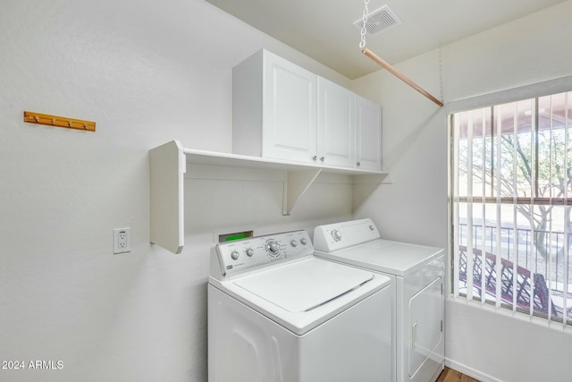 laundry area with cabinets, a wealth of natural light, and washer and clothes dryer