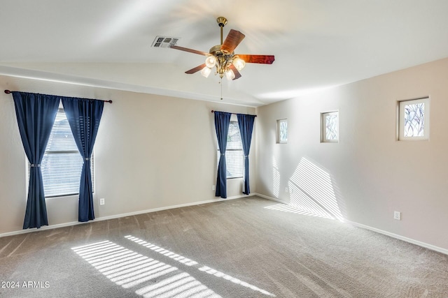 carpeted spare room featuring plenty of natural light, lofted ceiling, and ceiling fan