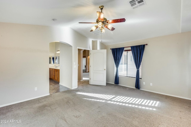 carpeted spare room with ceiling fan and lofted ceiling