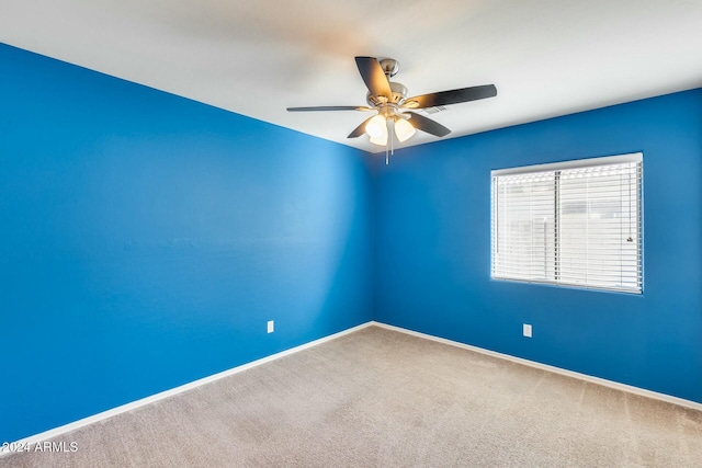 empty room featuring ceiling fan and carpet