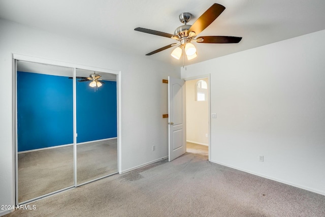 unfurnished bedroom with light carpet, a closet, and ceiling fan