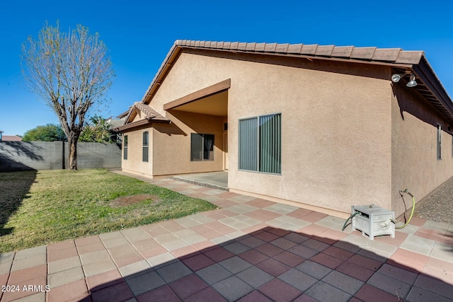 rear view of house with a patio area and a yard