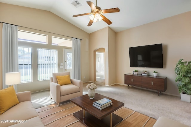 living room with ceiling fan, lofted ceiling, and light carpet