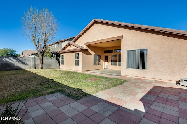 back of house with a patio area and a yard