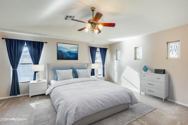 bedroom with ceiling fan, light carpet, and vaulted ceiling