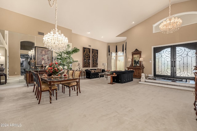 carpeted dining room featuring french doors, a chandelier, and high vaulted ceiling