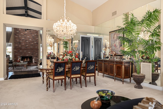 carpeted dining room with high vaulted ceiling, beam ceiling, a fireplace, and a chandelier