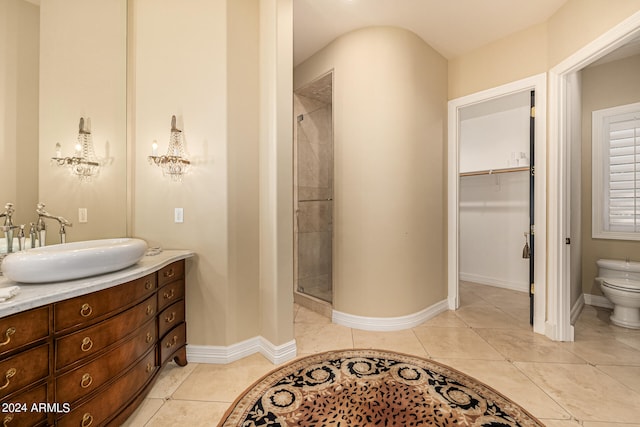 bathroom with vanity, toilet, a shower with door, and tile patterned floors