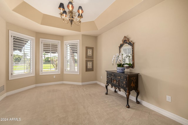 interior space with a tray ceiling and a chandelier